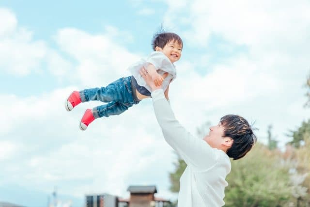 子どもを抱き上げる親