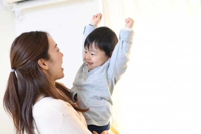 子どもを抱き上げる親