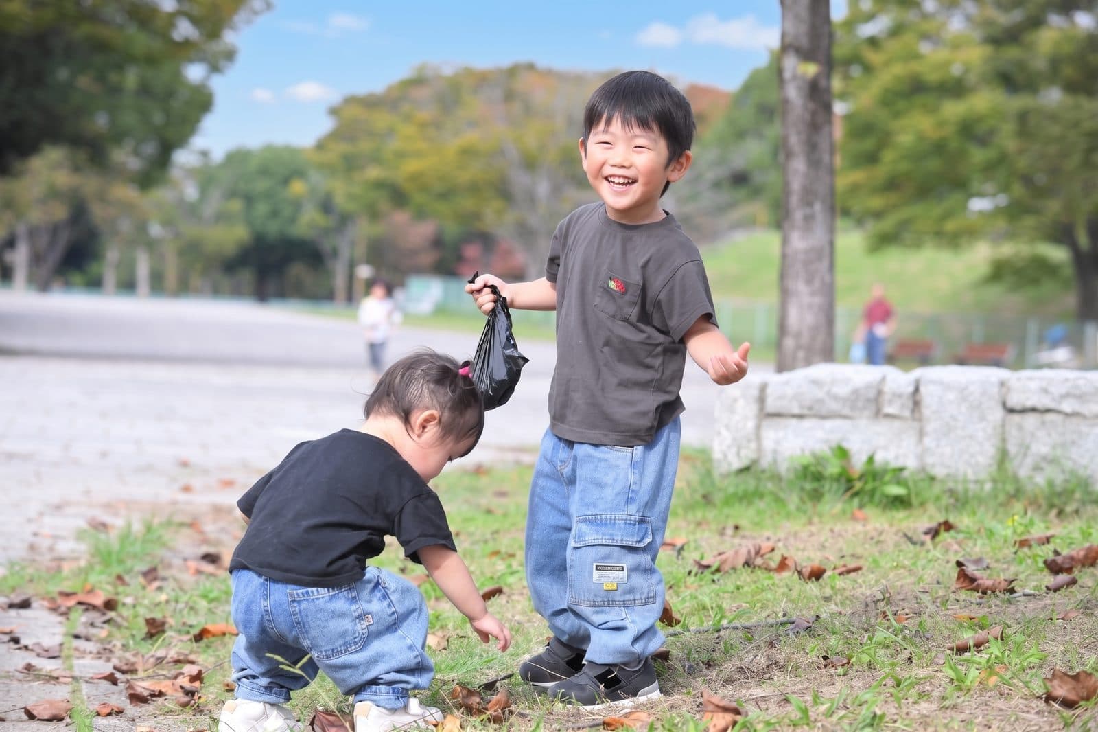 公園でどんぐりを拾う2人のお子さん